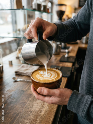 Fotografie Barista pouring steamed milk into a coffee cup to create latte art in a cafe
