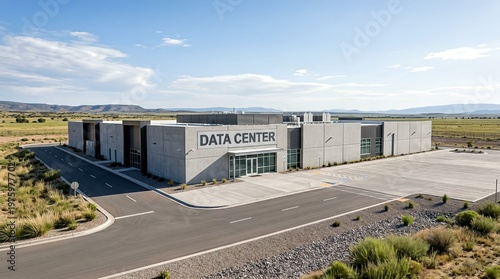 A large data center building situated in a remote area with clear skies, surrounded by fields.