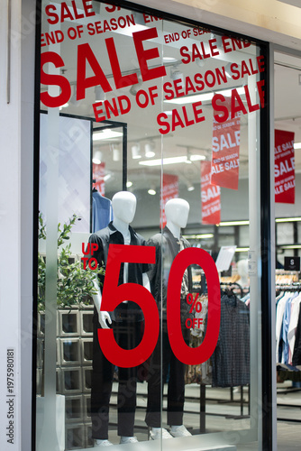 Red text on the sticker on the glass of window in the store with the inscription sale up to 50% off