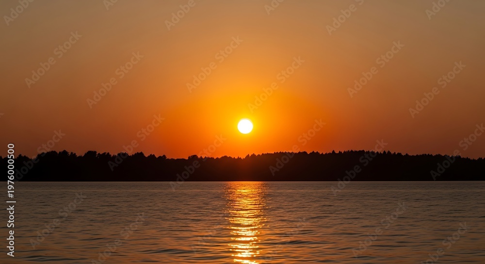 Obraz premium Sunset over the water with a beautiful orange sky.