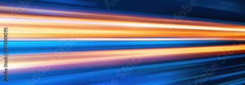 Bright, colorful light streaks in motion create a dynamic, futuristic abstract image with blue, orange, and yellow tones on a dark background.