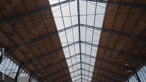 Keleti railway station glass ceiling and roof structure in Budapest, Hungary. Symmetrical low angle shot of the historic building interior
