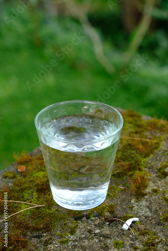 glass cup filled with mineral water on the stone table