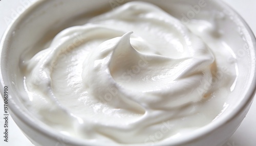 A bowl of creamy white yogurt on a clean white surface