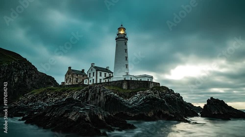 Lighthouse on Rock Cliffs Under Cloudy Sky.