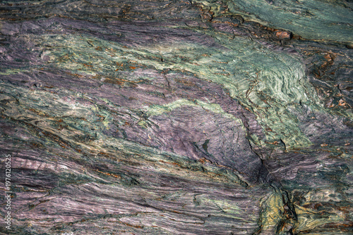Coppery colors in this background of natural mineral abstraction on a metamorphic rock