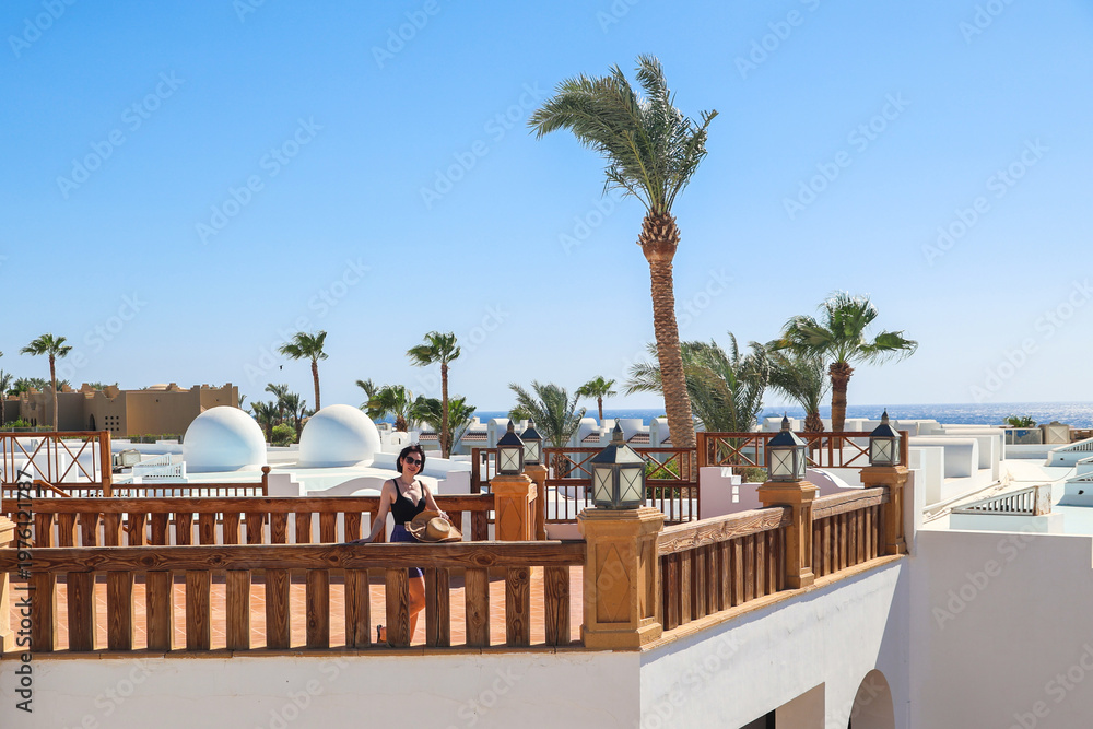 Fototapeta premium Traveler Woman Enjoying Breathtaking Sea View from Spacious Balcony of Egyptian Hotel, Embracing the Serenity of Nature.