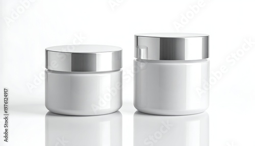 Two opaque white jars with shiny silver lids are slightly offset. The background is pure white. The composition conveys simplicity and elegance