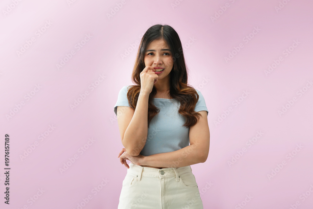 Obraz premium Thoughtful Indonesian woman touching chin while thinking, expressing curiosity or decision making against pink studio background