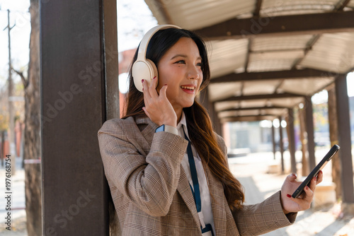 Asian businesswoman working on digital tablet with stylus outside modern building