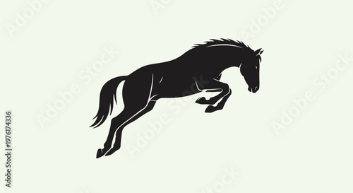 Silhouette of a powerful horse mid-leap against a pale background