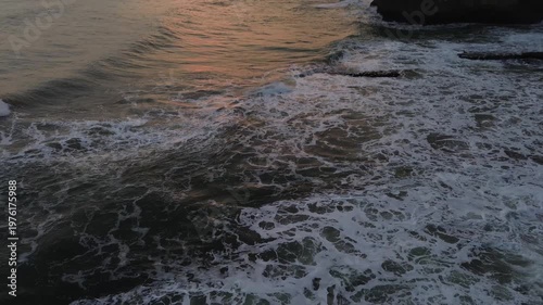 Golden sunset and sea waves at Karang Gantungan beach, Sukabumi, Indonesia.