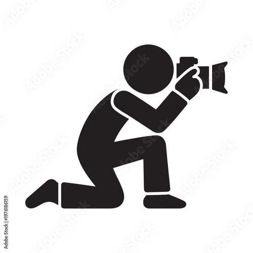 A black silhouette of a photographer kneeling and taking a picture