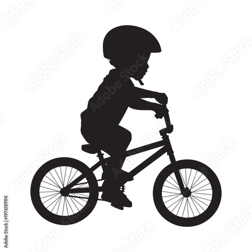 Silhouette of a young child riding a bicycle outdoors