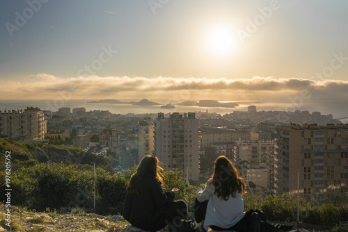 Marseille,  deux jeunes femmes admirent le coucher de soleil sur la ville. Vue depuis Notre Dame de la Garde