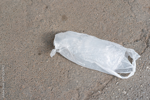 Wallpaper Mural Discarded Plastic Bag On Asphalt, Closeup Showing Crumpled Translucent Singleuse Bag Lying On Gritty Pavement With Sand And Tiny Pebbles, Muted Tones Conveying Urban Neglect And Environmental Torontodigital.ca