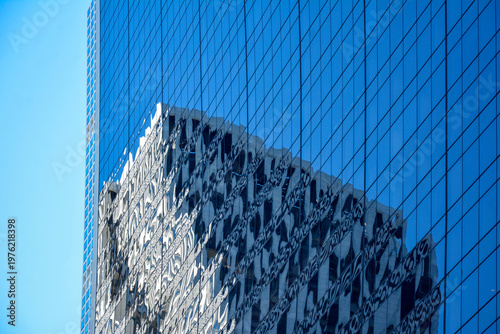 Modern skyscraper with a fully glass facade reflecting another building