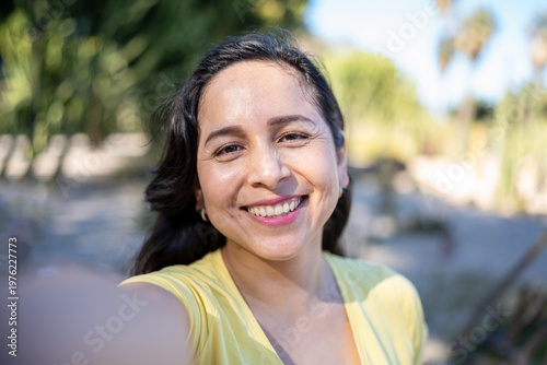 Happy Latin woman taking a selfie while enjoying outdoors during travel vacation
