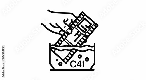 Hand developing film reel in liquid bath with C41 label