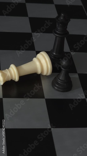 Aerial vertical pan over black chess pawns defensive line