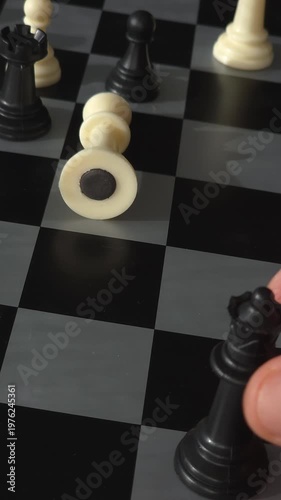 Hand making a checkmate move with black queen against white king