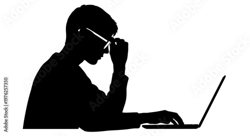 Silhouette of a man wearing glasses focused on his laptop screen while typing