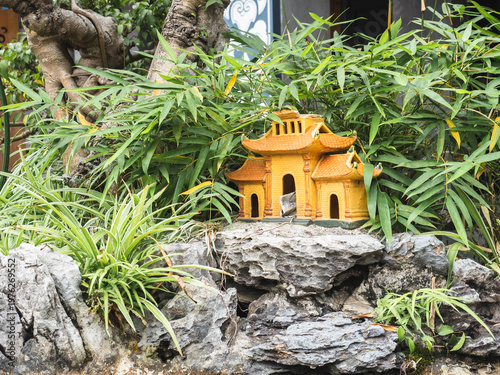 Fotografie Traditional Vietnamese landmarks with intricate architecture, lush trees, and vibrant flowers