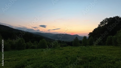 Breathtaking view of cloudy sundown sky over mountains in summer evening. Sunset sky over highlands. Nature concept