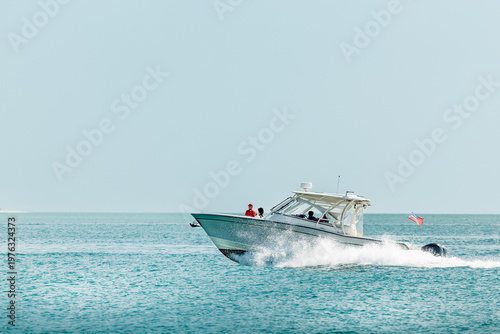 Saltwater fishing boat on a sunny summer day. People on recreational powerboat cruising the Gulf of America, Florida.