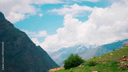4K Landscape shot of scenic snowy Himalayas with clouds above them during the summer season as seen from Marbal Village in Lahaul and Spiti district, Himachal Pradesh, India. Natural background.