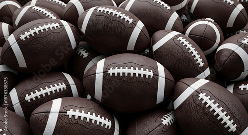 A dense pile of american footballs a close up view of leather and laces