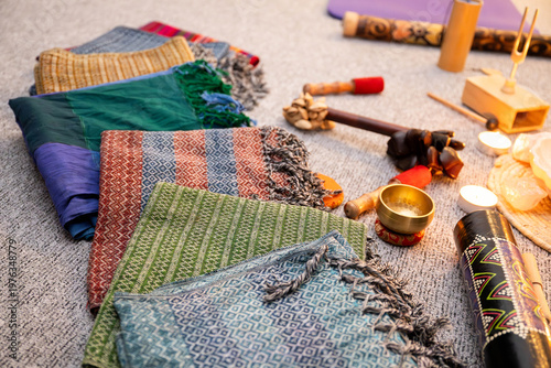 Rebozo massage and sound healing setup with Tibetan singing bowls, candles, yoga mats and traditional textiles, creating a calming wellness and holistic therapy atmosphere.

