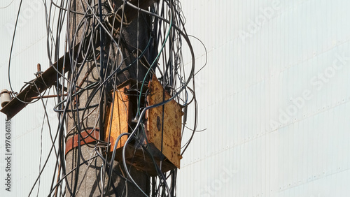 Canvas-taulu Electrical pole with tangled wires and rusty junction box in urban setting