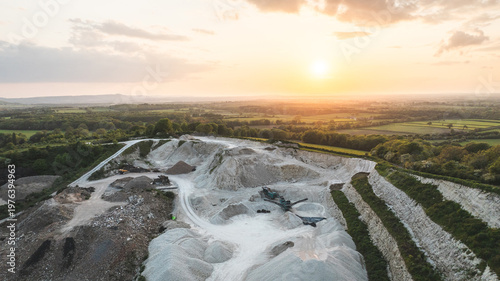 Fotografie Aerial view of a quarry at sunset with golden light illuminating the landscape