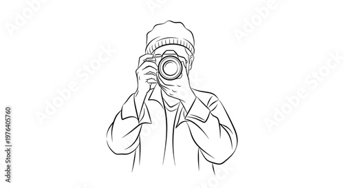 A person wearing a beanie and holding a digital SLR camera is preparing to capture an image, focusing intently through the viewfinder.