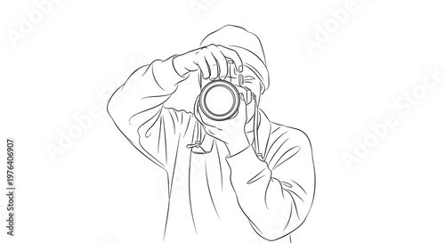 A person wearing a beanie and hoodie, holding a camera up to their face with a determined expression, ready to capture a shot.