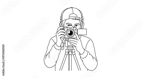 A dedicated photographer wearing a cap is intently looking through a camera viewfinder, capturing a moment with a tripod-mounted camera.