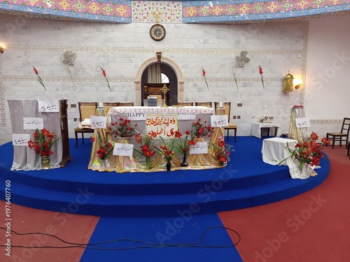 Obraz na plátne Ceremonial stage with floral arrangements and Arabic signage vector illustration