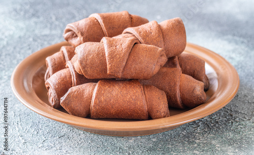 Fresh chocolate croissants on ceramic plate rustic bakery breakfast scene closeup composition
