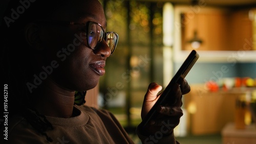 Obraz na plátně African American young woman relaxing alone and checking apps, scrolling social media on phone at home