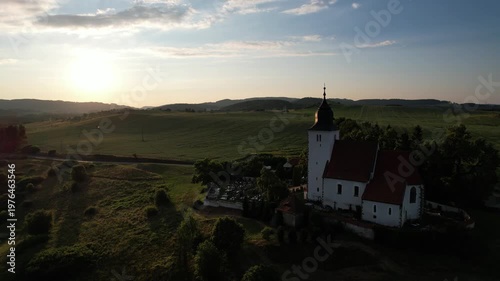 Remote Church of Saint Lawrence at Zdoun in Sumava mountains with cemetery captured as aerial panorama historic religious landmark