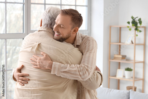 Senior man and his son hugg...