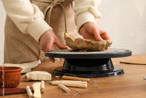 Young woman forming clay pl...