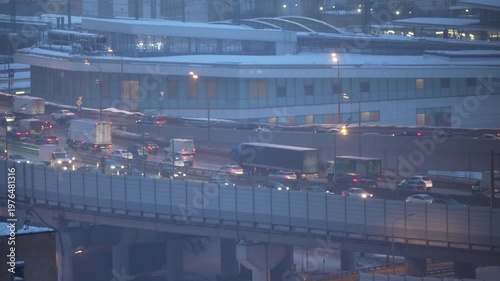 evening city highway with cars on elevated road urban traffic lights and cityscape winter dusk
