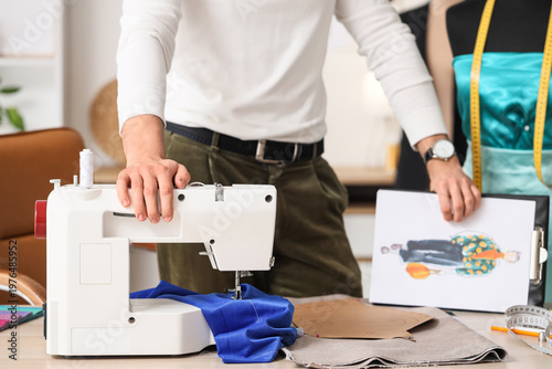 Young male tailor with sewi...