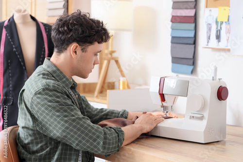 Young male tailor using sew...