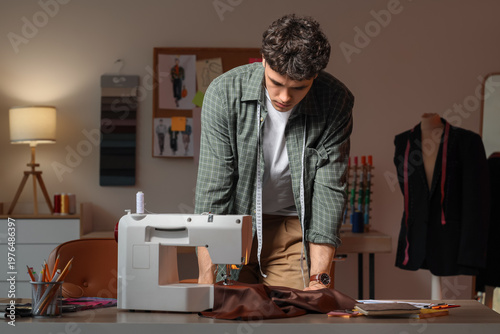 Young male tailor with sewi...
