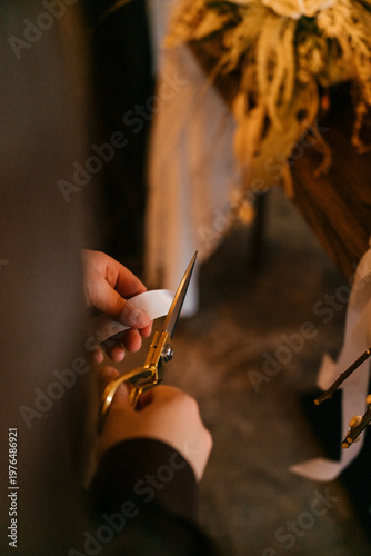Florist workspace with tools and dried flowers on a wooden table, capturing the process of creating handmade bouquets. A warm and authentic scene