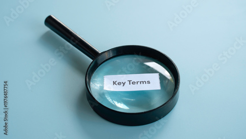 Bild auf Leinwand Magnifying glass placed over a paper note with the text key terms for education and contract research concepts