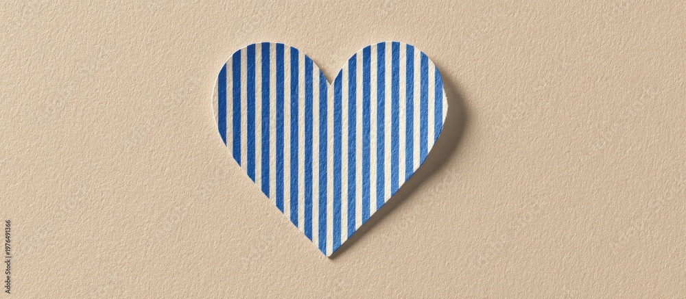 Obraz premium A blue and white striped heart cutout casts a slight shadow on a simple beige background